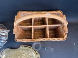 a wicker basket with a handle and a glass container on the table