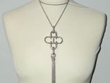 necklace with a chain and a key on a mannequin torso