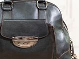 a black purse sitting on top of a wooden table