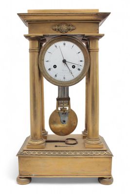 a gold clock sitting on top of a wooden table