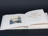 un livre ouvert posé sur une table, devant un fond noir