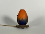 un objet en forme d'œuf, de couleur orange et bleue, posé sur un socle
