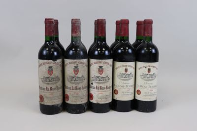 six bottles of wine are lined up in a row on a white surface