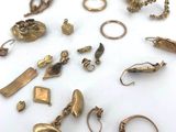 a lot of gold jewelry on a white surface