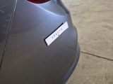 a sticker on the back of a car that is parked in a parking lot