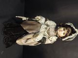 a doll that is standing on a black surface