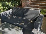 a black wicker couch and coffee table on the patio