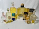 de nombreux flacons de parfum de toutes sortes posés sur une surface blanche