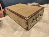 a brown suitcase sitting on a wooden floor next to a pair of shoes