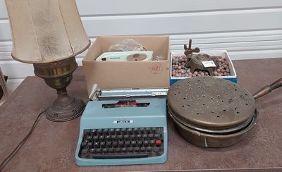 une machine à écrire bleue posée sur une table, à côté d'une lampe