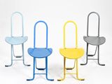 trois chaises de couleurs différentes sont disposées côte à côte sur une surface blanche