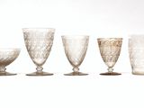 five glasses sitting next to each other on a white surface