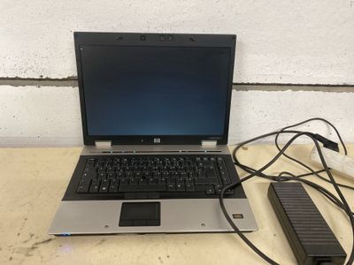un ordinateur portable posé sur une table avec un chargeur