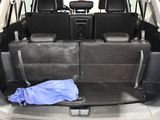 the back seats of a car with a blue blanket in the trunk