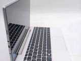 a white laptop with a black keyboard on a white table