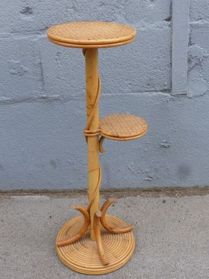 une petite table avec deux tabourets posée sur le trottoir