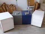 une pièce avec un bureau, une chaise, une lampe et quelques cartons