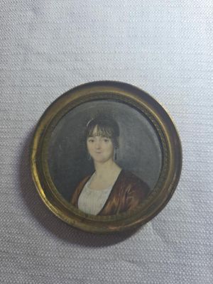 an old picture of a woman in a brown dress in a gold frame