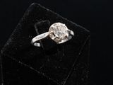 an image of a diamond ring sitting on top of a black velvet box