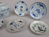 several blue and white plates and vases with designs on them