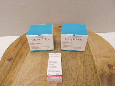 two boxes of clarins on a wooden table