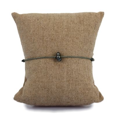 a brown pillow with a black button on it