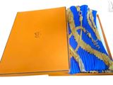 an orange box with a blue and gold scarf inside of it