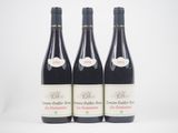 trois bouteilles de vin rouge posées l'une à côté de l'autre sur une surface blanche