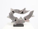 a metal sculpture on a white surface with a white background
