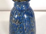 a blue vase that is sitting on a white surface