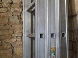 une échelle métallique appuyée contre un mur de briques