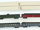 quatre petits trains miniatures dans une vitrine posée sur une surface blanche