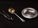 une assiette en argent avec une cuillère et un repose-cuillère à côté