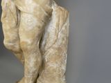 marble statue of a boy holding a bird on a rock