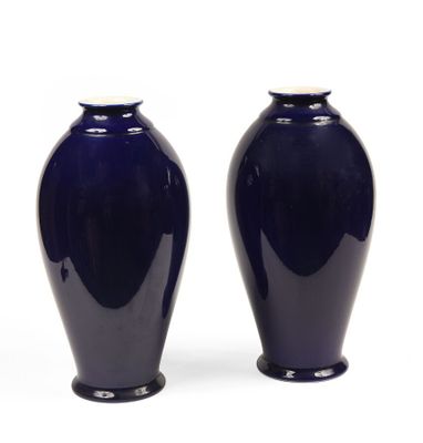 une paire de vases bleu foncé posés sur une surface blanche