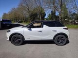 a white suv parked in a parking lot with trees in the background