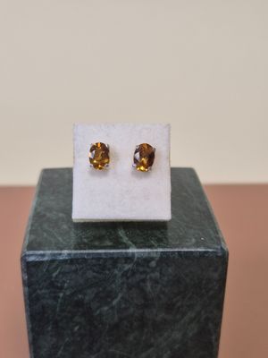 un gros plan sur une paire de boucles d'oreilles posées sur un bloc de marbre
