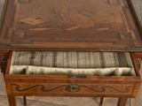 a small table with a drawer underneath it on a tile floor