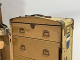 a suitcase and a chest of drawers sitting next to each other
