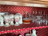 de nombreuses tasses et verres sur une étagère dans la cuisine