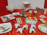 many plates and bowls on a table with a red table cloth