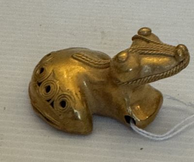 une figurine d'éléphant en or posée sur une surface blanche