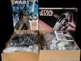 two boxes of star wars action figures sit side by side