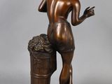 bronze statue of a man with a bucket of grapes