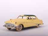 yellow toy car sitting on top of a white surface next to a white wall