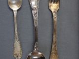 three spoons, a fork, and a spoon on a table