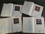 six books with drawings on them sitting on a table