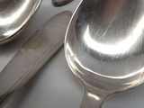 several spoons and spoon knives are lined up on a table