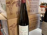 two bottles of wine sitting on a counter next to boxes of wine