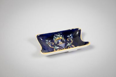 une petite assiette bleue et jaune décorée de fleurs